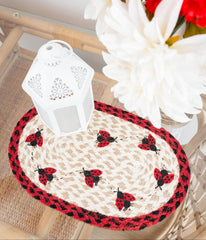 ladybug placemat or trivet with red and black ladybugs and red and black border and tan braided jute for cottage core or spring table. 