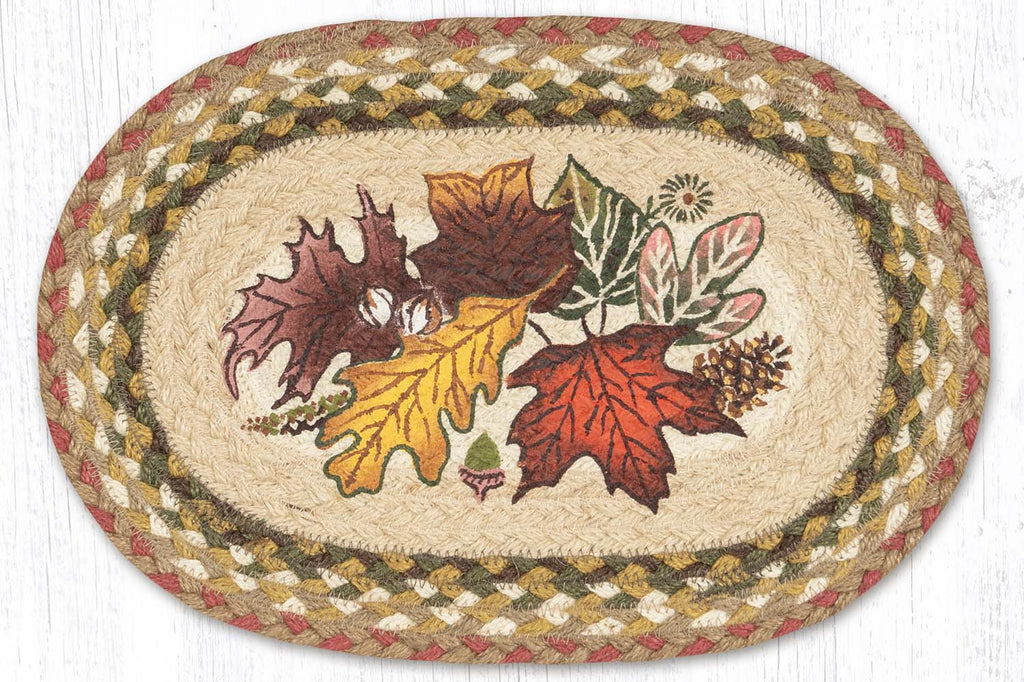 placemat with autumn leaves design in center made from braided jute in gold, green, burgundy, and tan colors. 