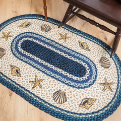 Seashell rug for beach coastal theme home. Blue, tan, and white with braided jute texture.