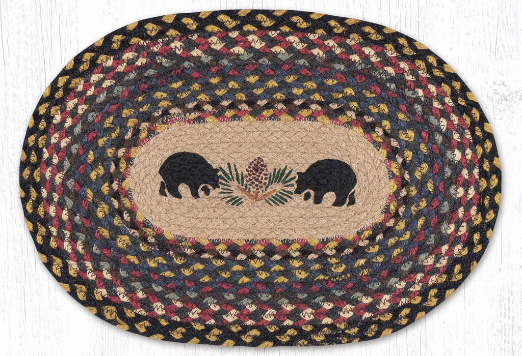 Oval placemat with black bear silhouette and pinecone design in center